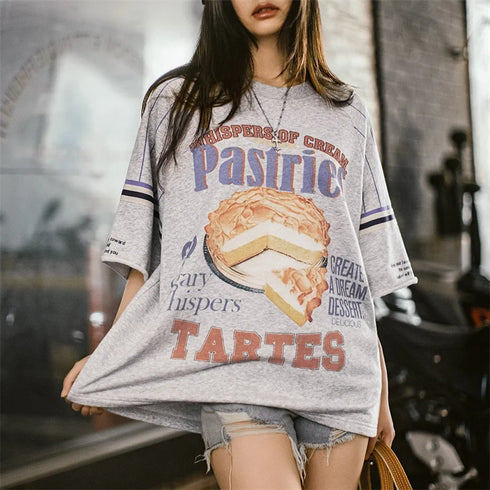 Person wearing a gray t-shirt with dessert-themed graphics and text.